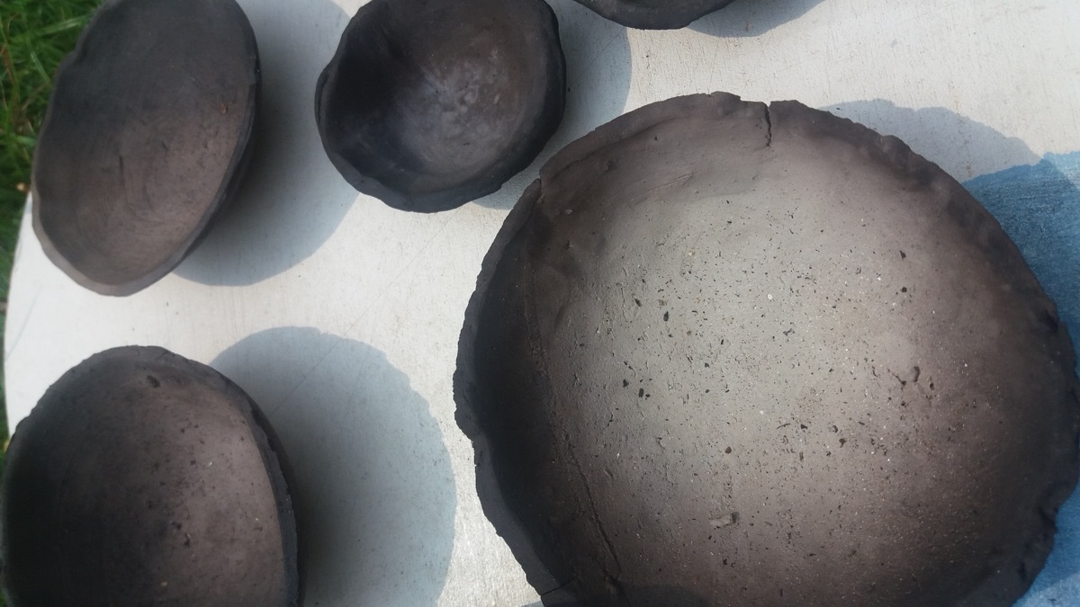 Smoke-fired clay bowls drying in the sun